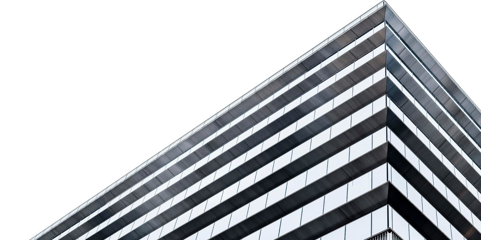 A photo of a modern office building from below and the sky.