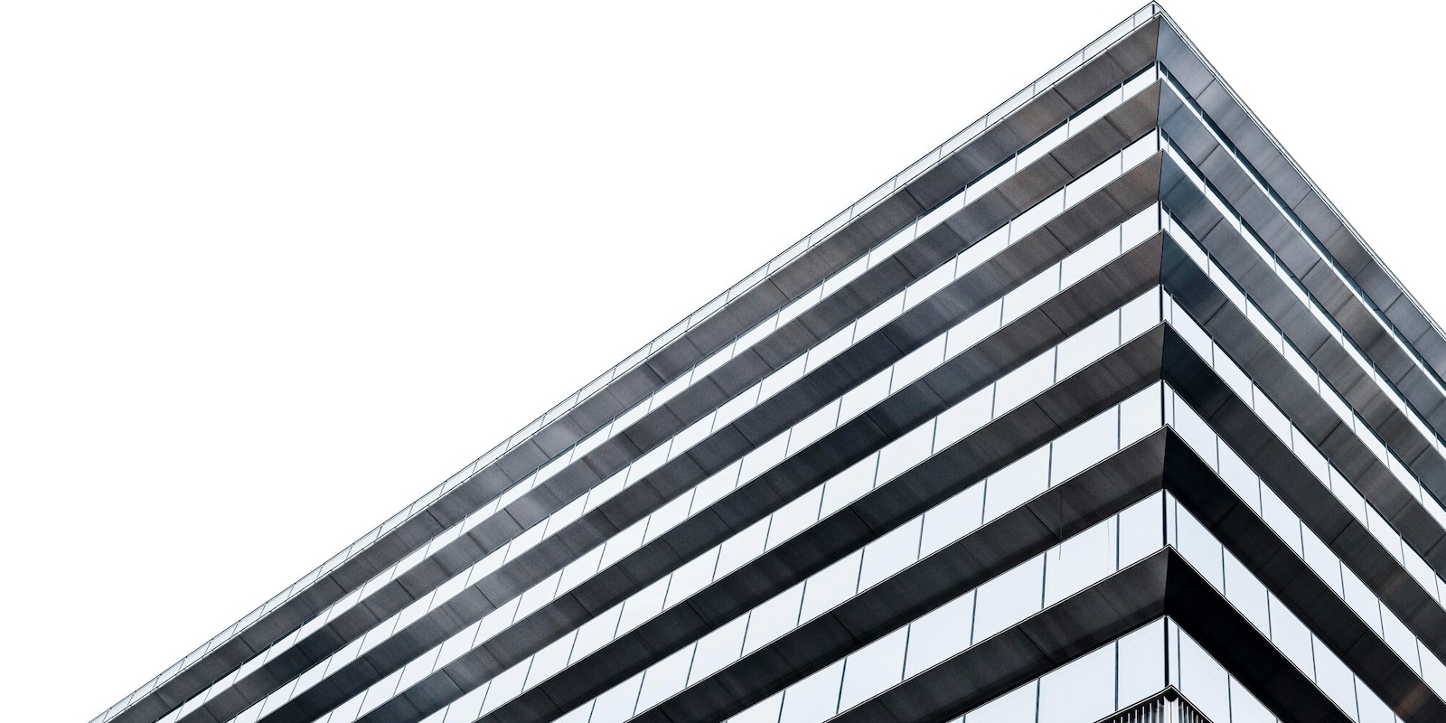 A photo of a modern office building from below and the sky.